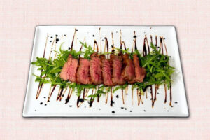 tagliata di vitello piemontese con rucola e glassa di aceto balsamico i due mondi busca